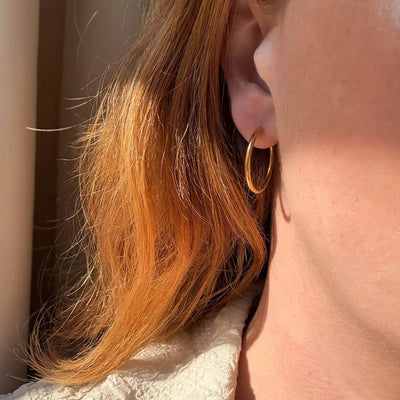 Boucles d’oreilles créoles dorées - disponibles en plusieurs tailles.