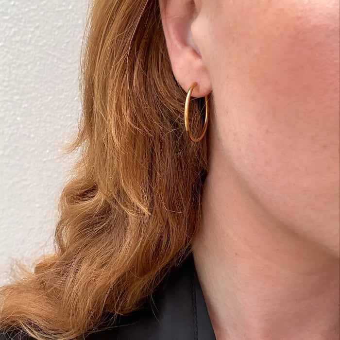 Boucles d’oreilles créoles dorées - disponibles en plusieurs tailles.